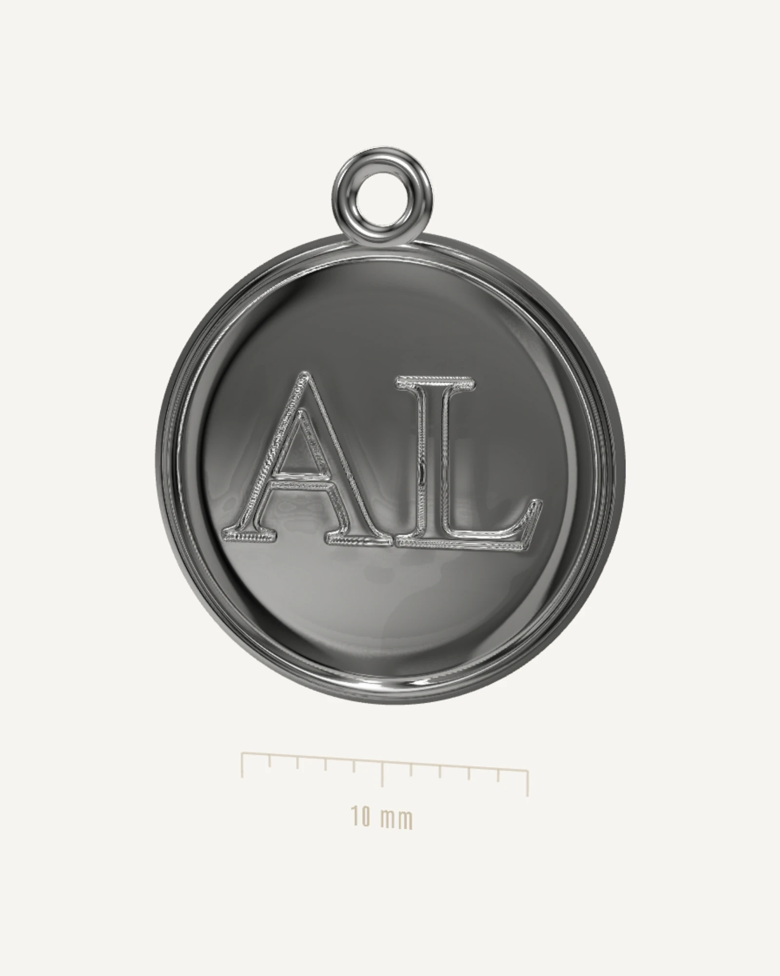 Rendu de l’atelier : une médaille ronde en argent, gravée d’un monogramme